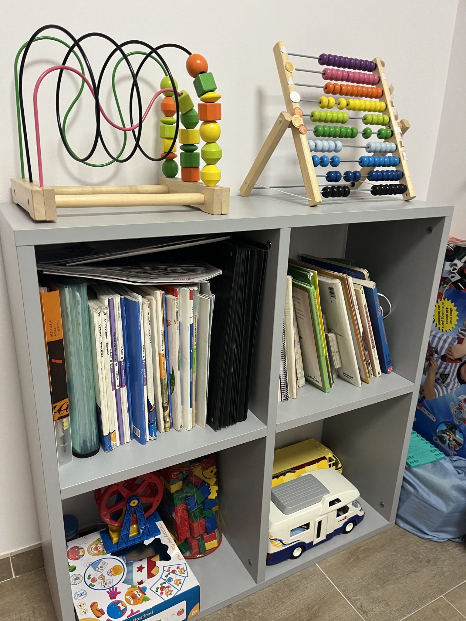 Estantería con juguetes y libros educativos.