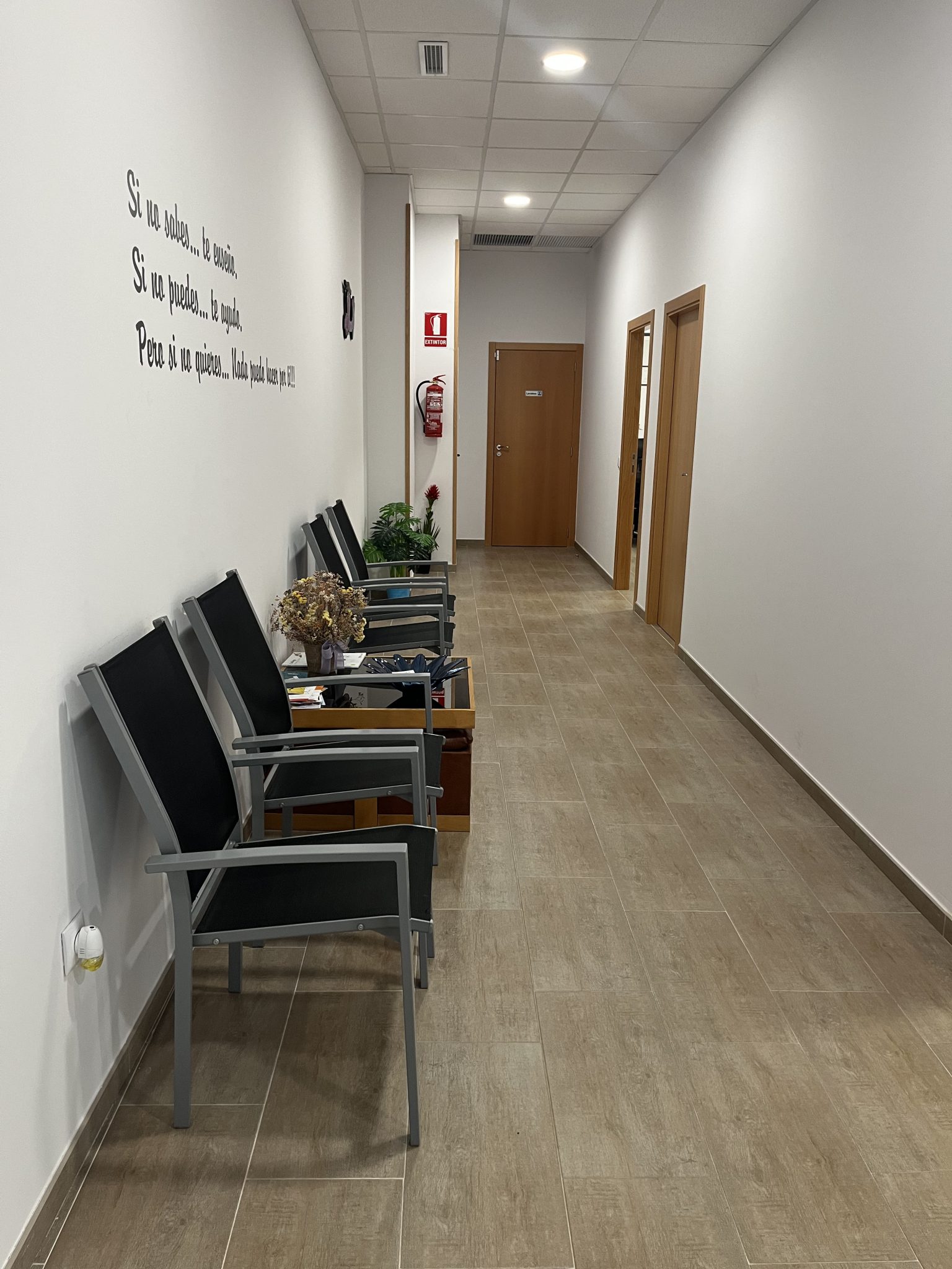 Pasillo moderno con sillas y decoración minimalista.