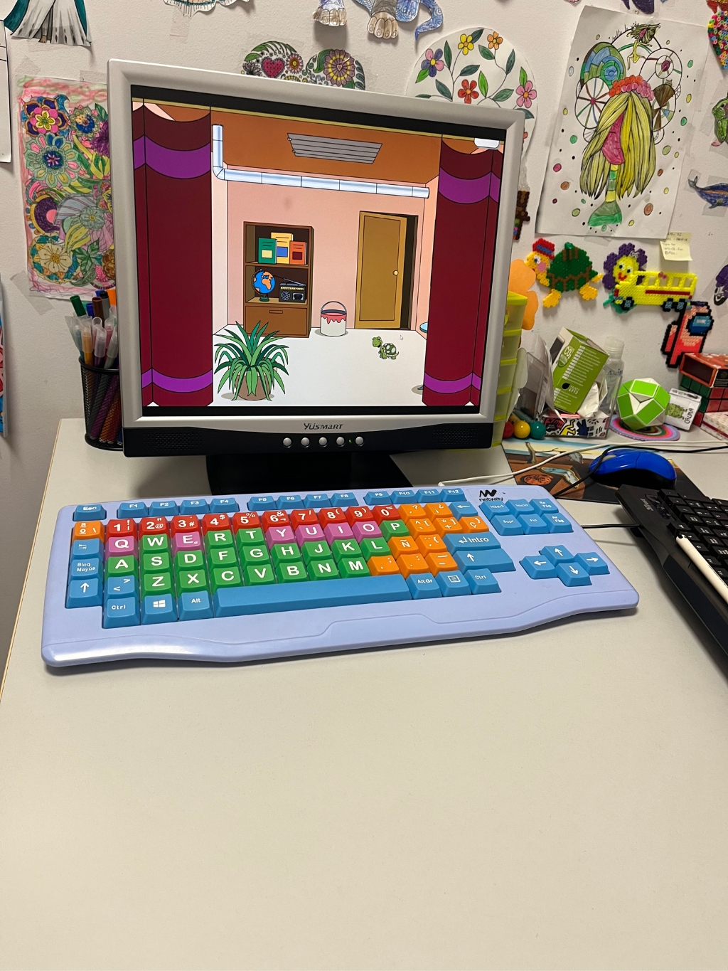 Pantalla con dibujos animados y teclado colorido.